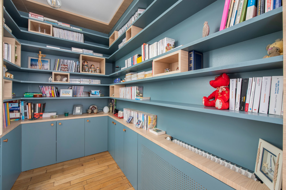 Esempio di un piccolo studio nordico con libreria, pareti blu, pavimento in legno massello medio, nessun camino e pavimento marrone