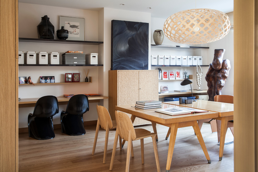 Cette photo montre un grand bureau tendance avec un mur blanc, un sol en bois brun et un bureau indépendant.