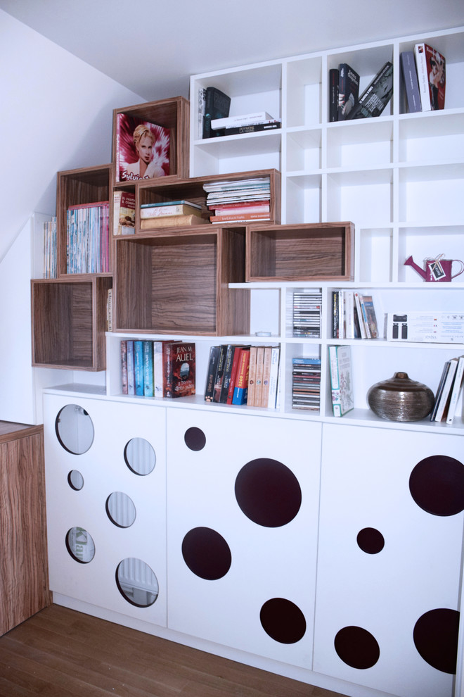 パリにあるお手頃価格の中くらいなコンテンポラリースタイルのおしゃれなホームオフィス・書斎 (ライブラリー、白い壁、淡色無垢フローリング、暖炉なし、造り付け机、茶色い床) の写真