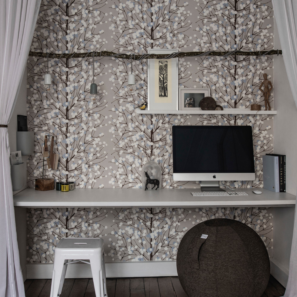 This is an example of a small scandi study in Paris with beige walls, medium hardwood flooring, a built-in desk and brown floors.