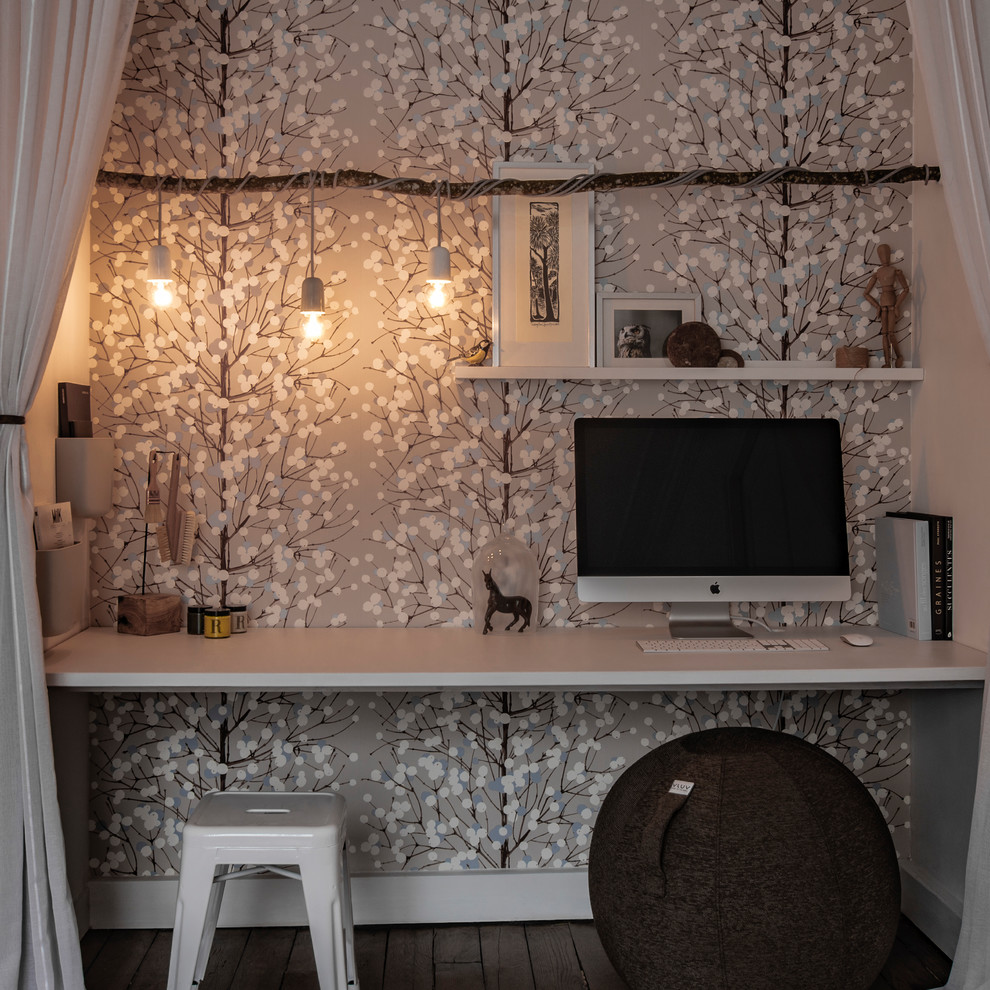 Inredning av ett minimalistiskt litet hemmabibliotek, med beige väggar, mellanmörkt trägolv, ett inbyggt skrivbord och brunt golv