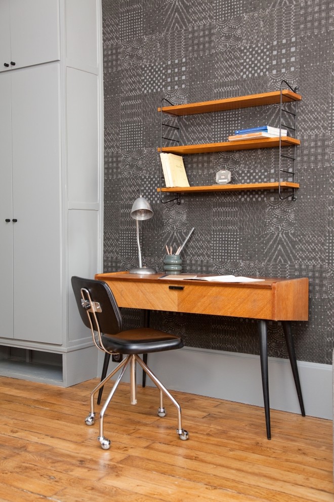 Modernes Arbeitszimmer mit Arbeitsplatz, grauer Wandfarbe, braunem Holzboden und freistehendem Schreibtisch in Paris