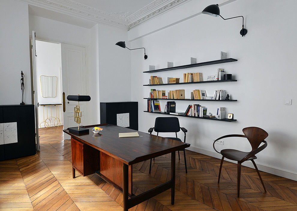 Cette image montre un grand bureau traditionnel avec une bibliothèque ou un coin lecture, un mur blanc, aucune cheminée, un bureau indépendant, un sol marron et un sol en bois brun.