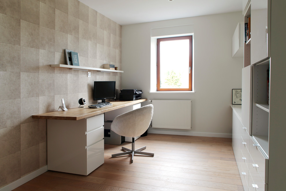 Modernes Arbeitszimmer mit Arbeitsplatz, bunten Wänden, braunem Holzboden, freistehendem Schreibtisch und orangem Boden in Rennes