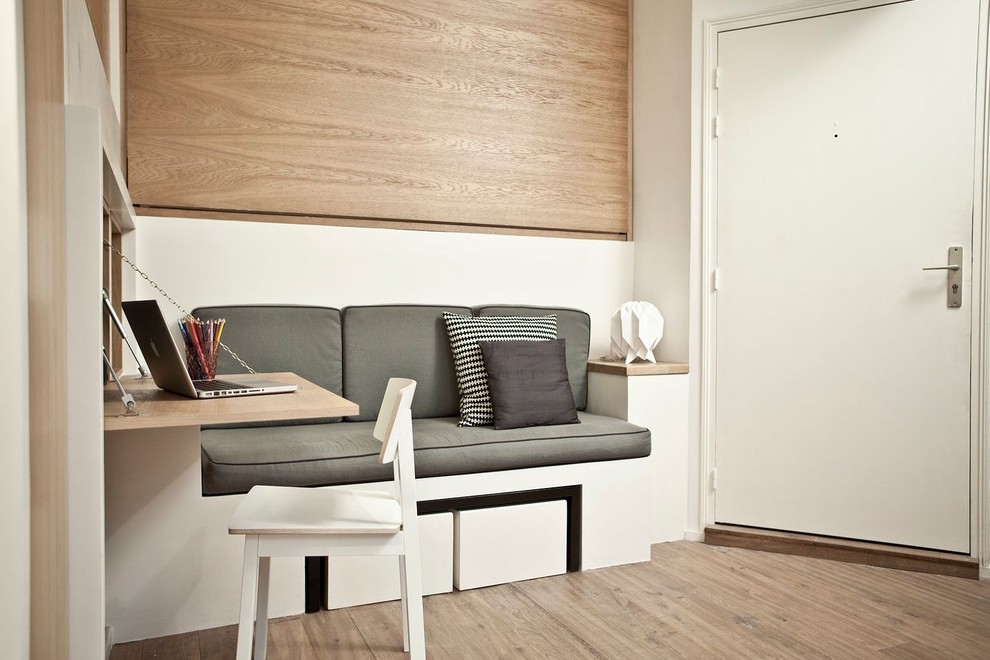 Idee per un piccolo ufficio minimal con pareti bianche, pavimento in legno massello medio e scrivania incassata