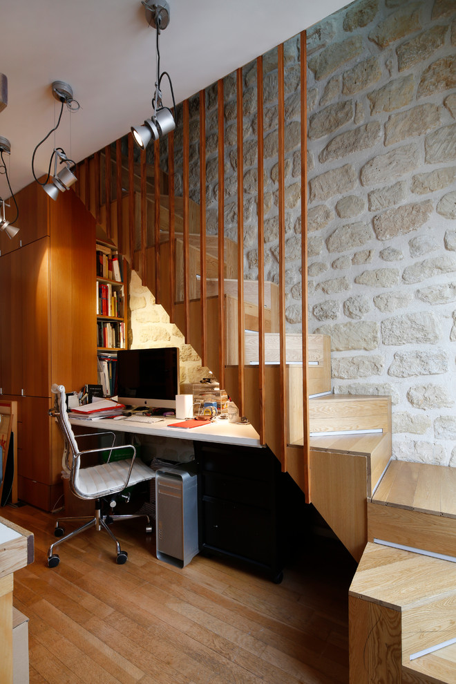 Imagen de despacho actual pequeño con paredes blancas, suelo de madera en tonos medios y escritorio empotrado