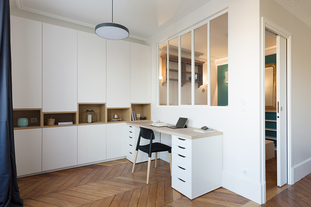Example of a small danish freestanding desk light wood floor study room design in Paris