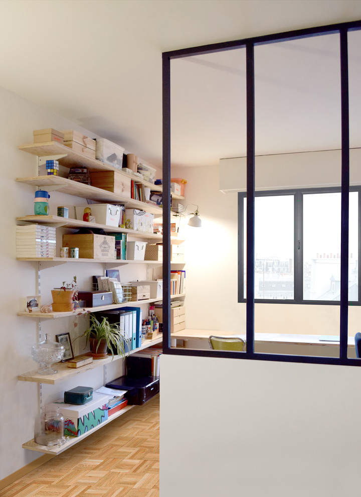 Diseño de despacho nórdico pequeño con paredes blancas, suelo de madera clara y escritorio independiente