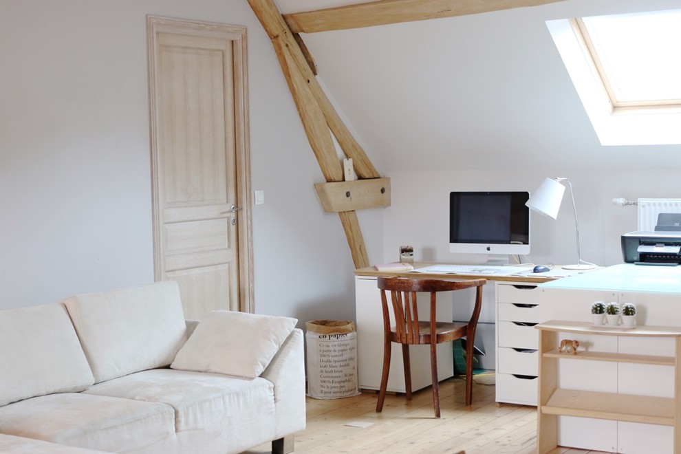 Großes Skandinavisches Arbeitszimmer ohne Kamin mit Arbeitsplatz, grauer Wandfarbe, hellem Holzboden, Einbau-Schreibtisch und beigem Boden in Paris