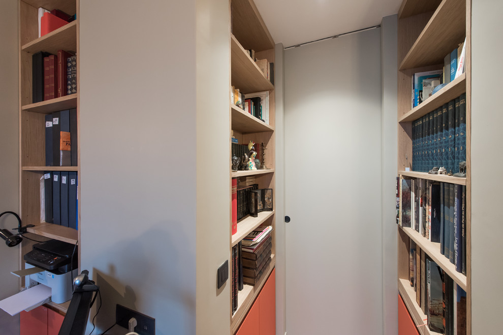 Foto di uno studio classico di medie dimensioni con libreria e pareti grigie