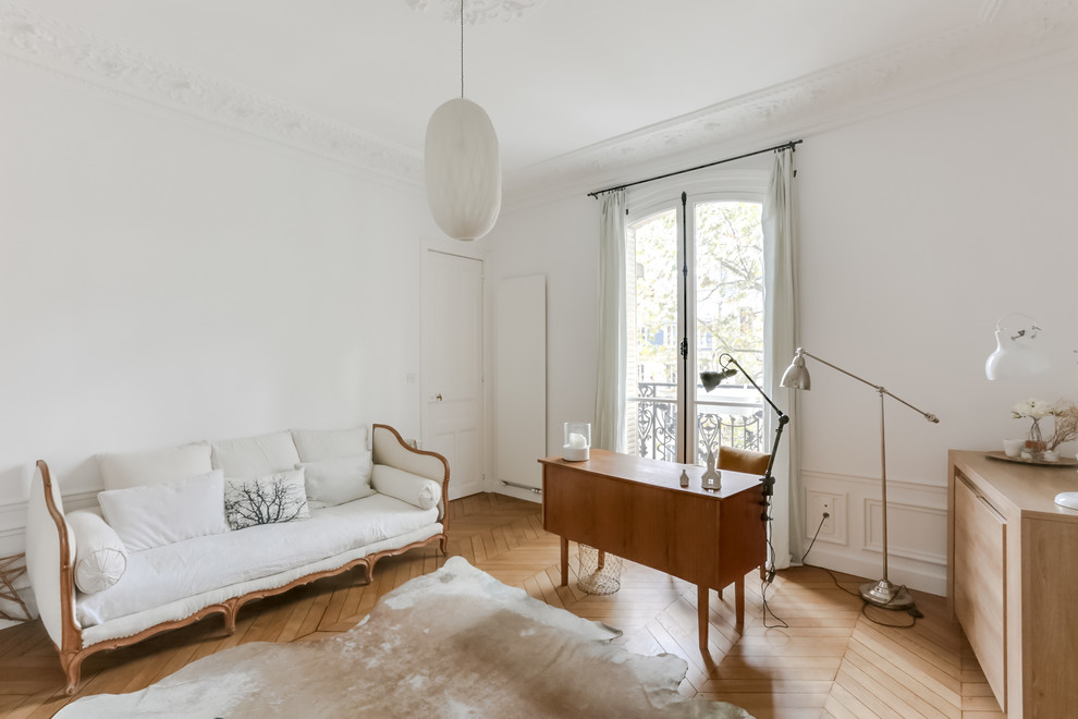 Example of a mid-sized classic freestanding desk light wood floor study room design in Paris with white walls and no fireplace