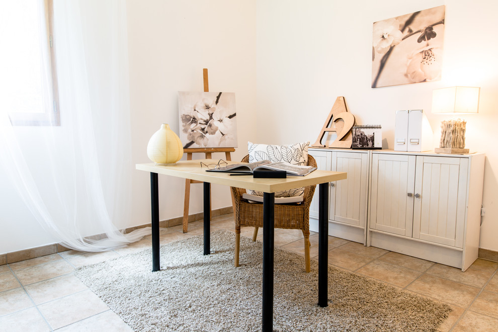 Ejemplo de despacho de estilo de casa de campo de tamaño medio con paredes beige y escritorio independiente