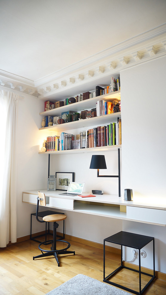 Idee per un ufficio minimal di medie dimensioni con pareti bianche, pavimento in legno massello medio e scrivania incassata