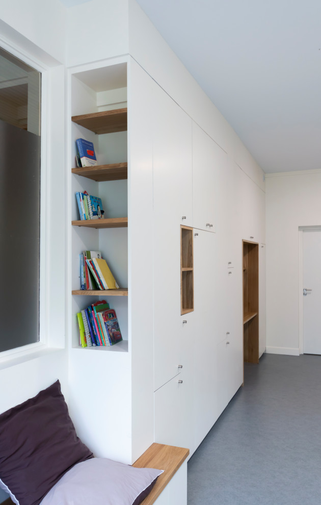Foto de despacho contemporáneo pequeño con biblioteca, paredes blancas, suelo de linóleo, escritorio empotrado y suelo gris
