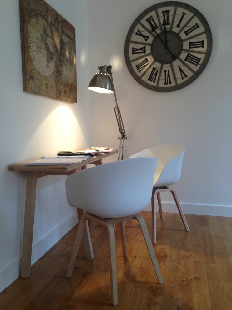 Cette image montre un petit bureau design avec un mur blanc, un bureau indépendant, un sol en bois brun et un sol beige.