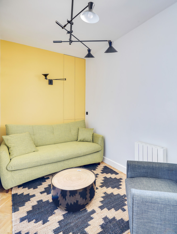 Kleines Modernes Arbeitszimmer ohne Kamin mit Studio, gelber Wandfarbe, hellem Holzboden, freistehendem Schreibtisch, beigem Boden und Tapetenwänden in Paris