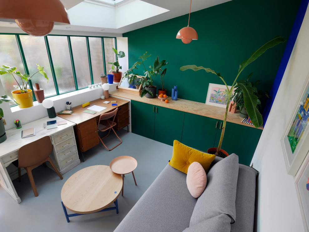 Foto di una stanza da lavoro minimalista di medie dimensioni con pareti verdi, pavimento in cemento, scrivania autoportante e pavimento grigio