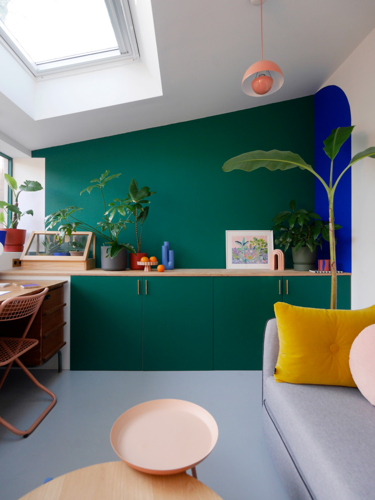 Cette image montre un bureau atelier minimaliste de taille moyenne avec un mur vert, sol en béton ciré, un bureau indépendant et un sol gris.
