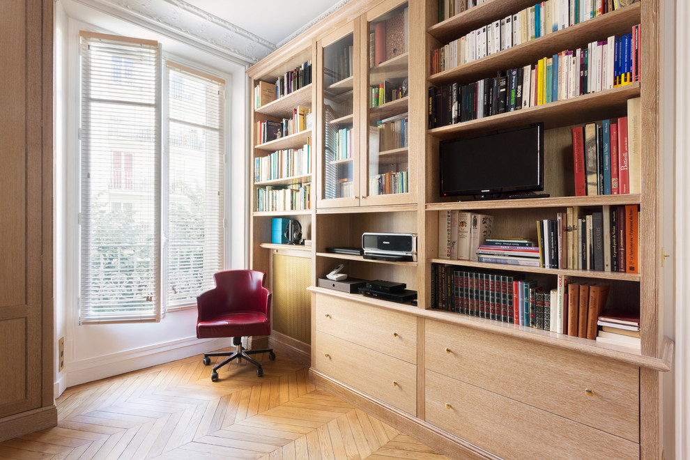 パリにある高級な広いトランジショナルスタイルのおしゃれな書斎 (ベージュの壁、無垢フローリング、造り付け机、オレンジの床) の写真