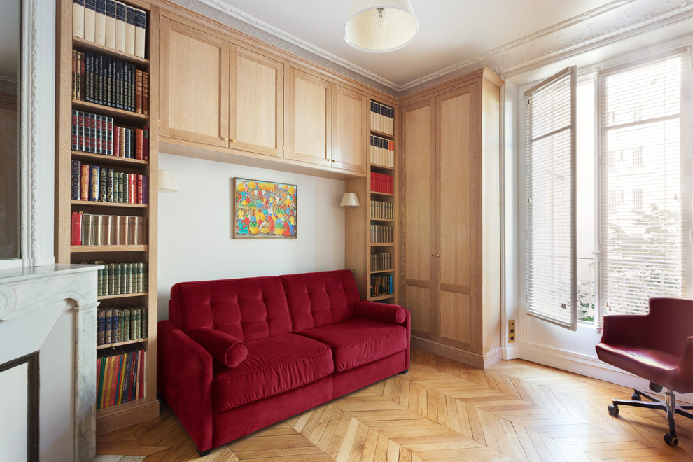 Inredning av ett klassiskt stort hemmabibliotek, med beige väggar, mellanmörkt trägolv, en öppen hörnspis, en spiselkrans i sten, ett inbyggt skrivbord och orange golv
