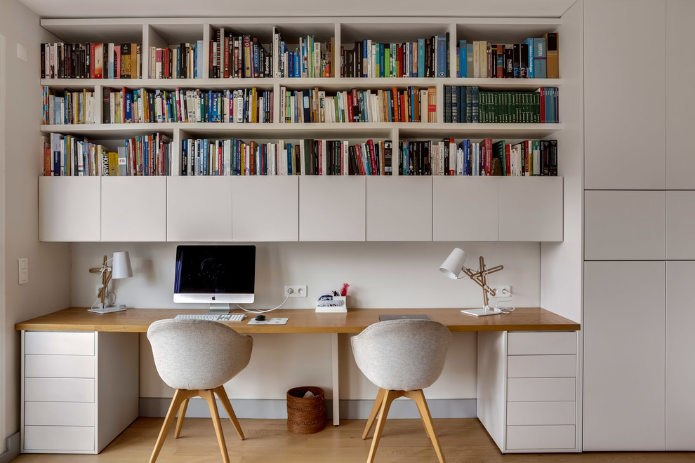 Inspiration för nordiska arbetsrum, med vita väggar, mellanmörkt trägolv, ett inbyggt skrivbord och brunt golv