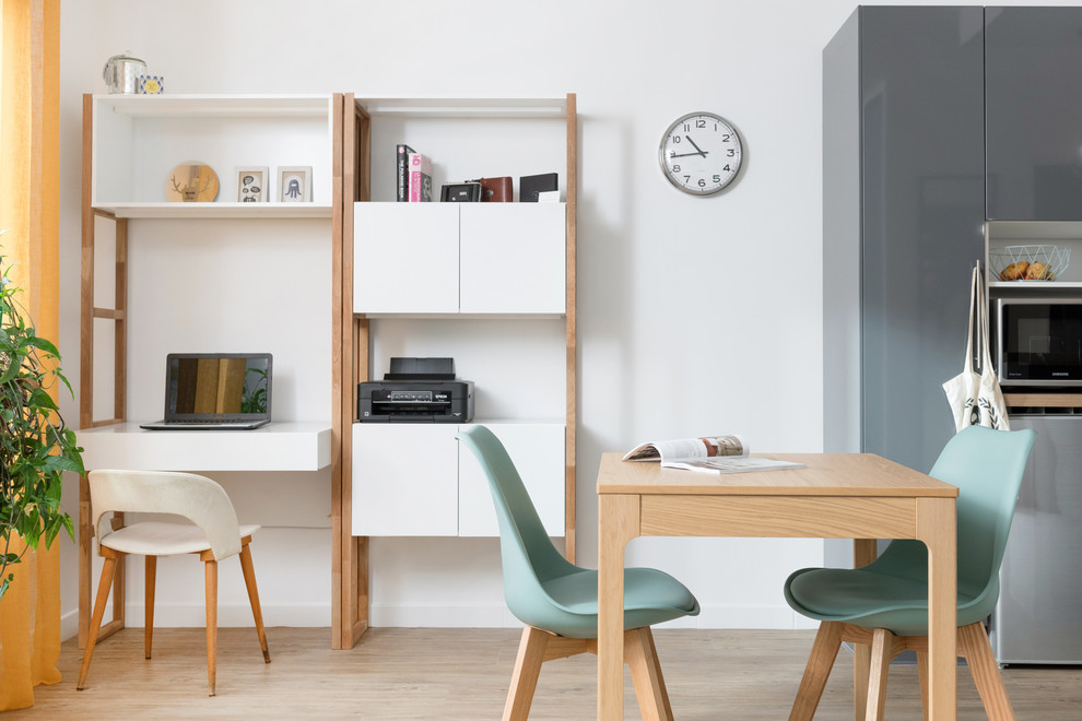 Bild på ett litet minimalistiskt hemmabibliotek, med vita väggar, vinylgolv och ett fristående skrivbord