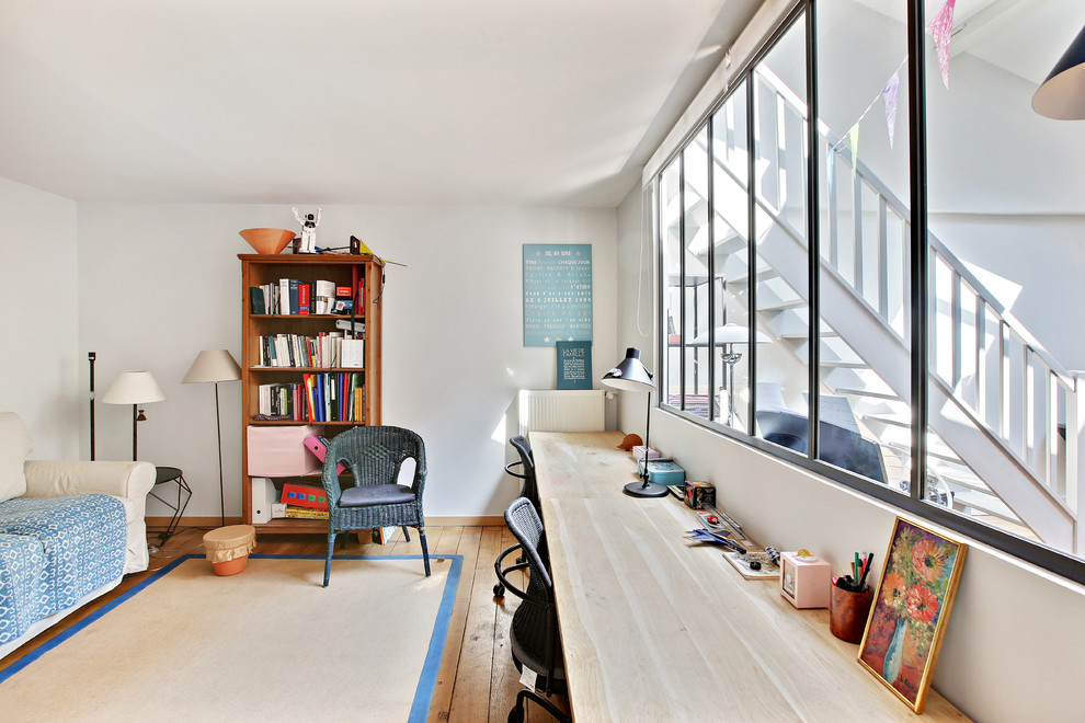Immagine di un ufficio industriale con pareti bianche, pavimento in legno massello medio, scrivania autoportante e pavimento marrone