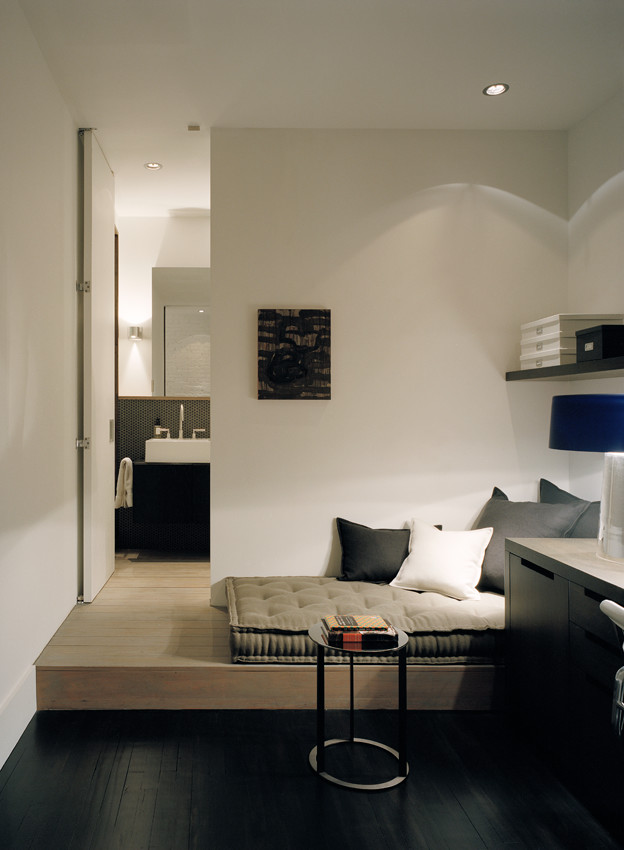 Idee per un piccolo ufficio minimalista con pareti bianche, parquet scuro e scrivania incassata