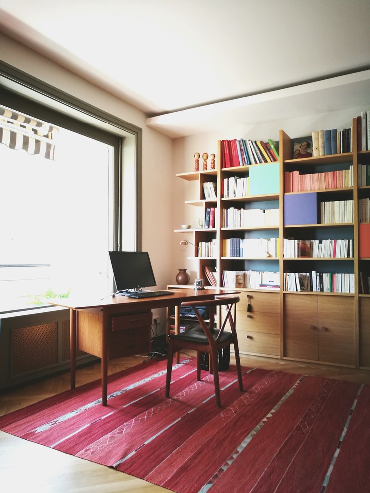 Inspiration för ett mellanstort funkis hemmabibliotek, med vita väggar och ljust trägolv