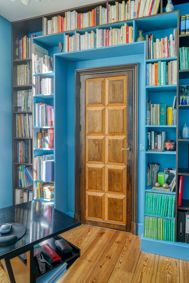 Foto de despacho asiático pequeño sin chimenea con paredes azules, suelo de madera clara y escritorio independiente