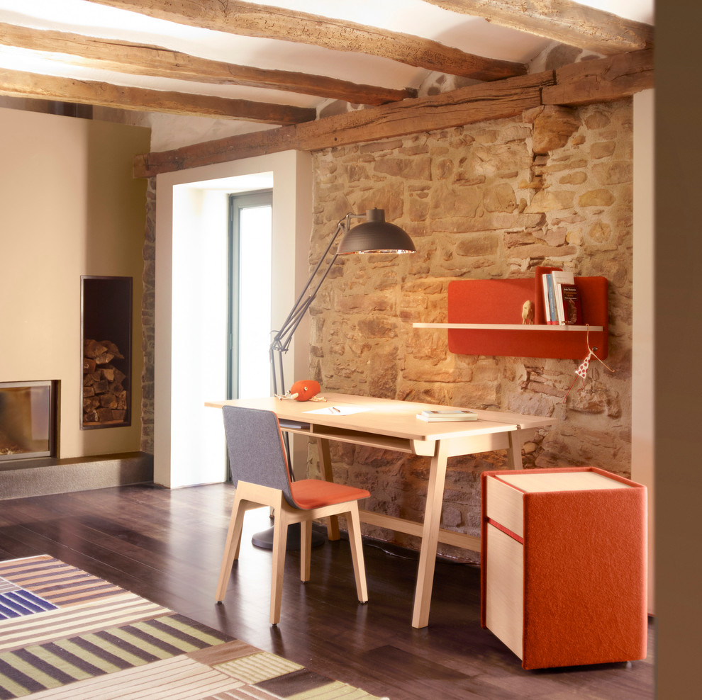 Idee per un ufficio minimal di medie dimensioni con pareti beige, parquet scuro, camino classico e scrivania autoportante