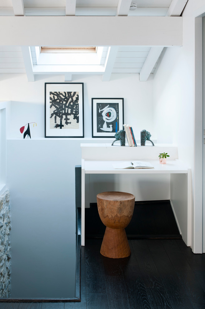 Ejemplo de despacho marinero pequeño sin chimenea con paredes blancas, suelo de madera oscura y escritorio empotrado