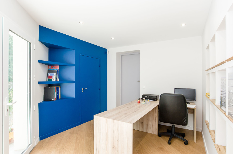 Idée de décoration pour un bureau design avec un mur bleu, un sol en bois brun, aucune cheminée et un bureau indépendant.