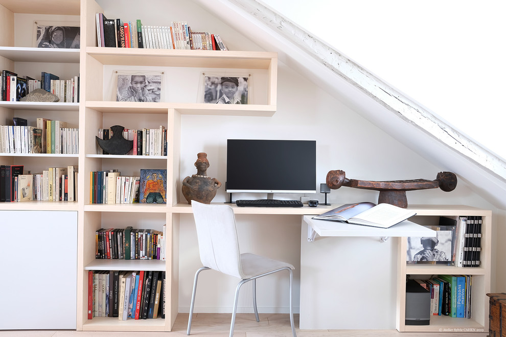 Bild på ett mellanstort funkis arbetsrum, med ett bibliotek, ljust trägolv, ett inbyggt skrivbord, vita väggar och brunt golv