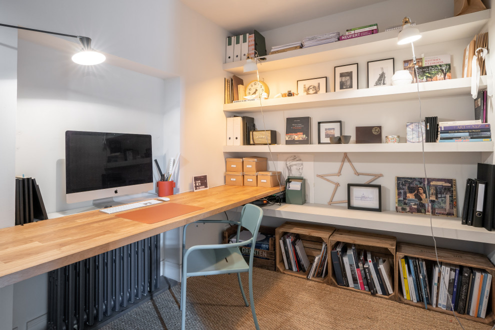 Immagine di uno studio con pareti bianche, moquette, scrivania incassata e pavimento marrone