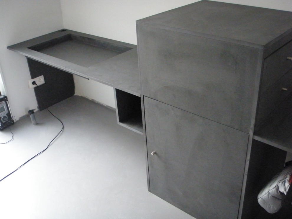 Imagen de despacho moderno con paredes beige, suelo de cemento y escritorio empotrado