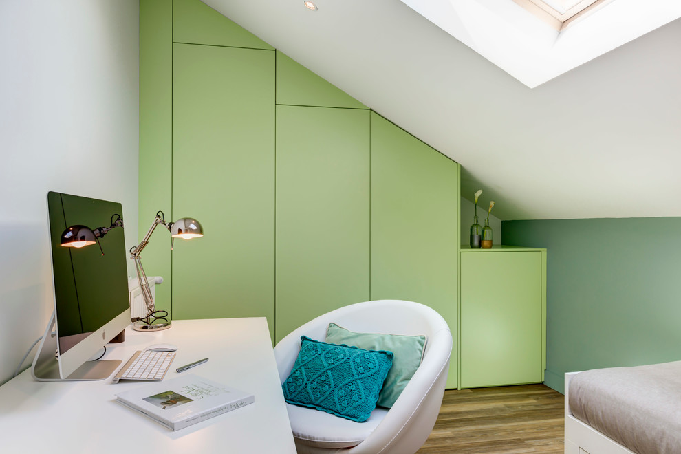 Foto de despacho actual de tamaño medio con paredes verdes, suelo de madera en tonos medios y escritorio independiente