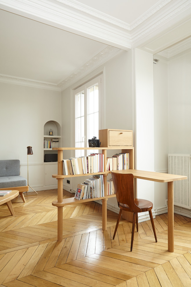 На фото: кабинет в стиле модернизм с белыми стенами, светлым паркетным полом и встроенным рабочим столом без камина