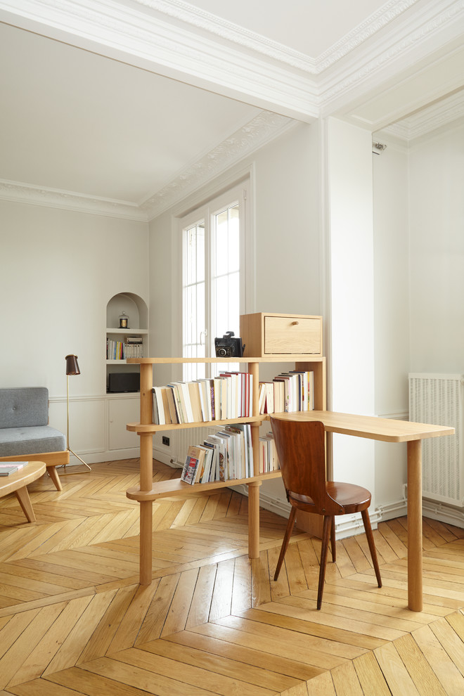 Modern home office in Paris with white walls, light hardwood flooring, no fireplace and a built-in desk.