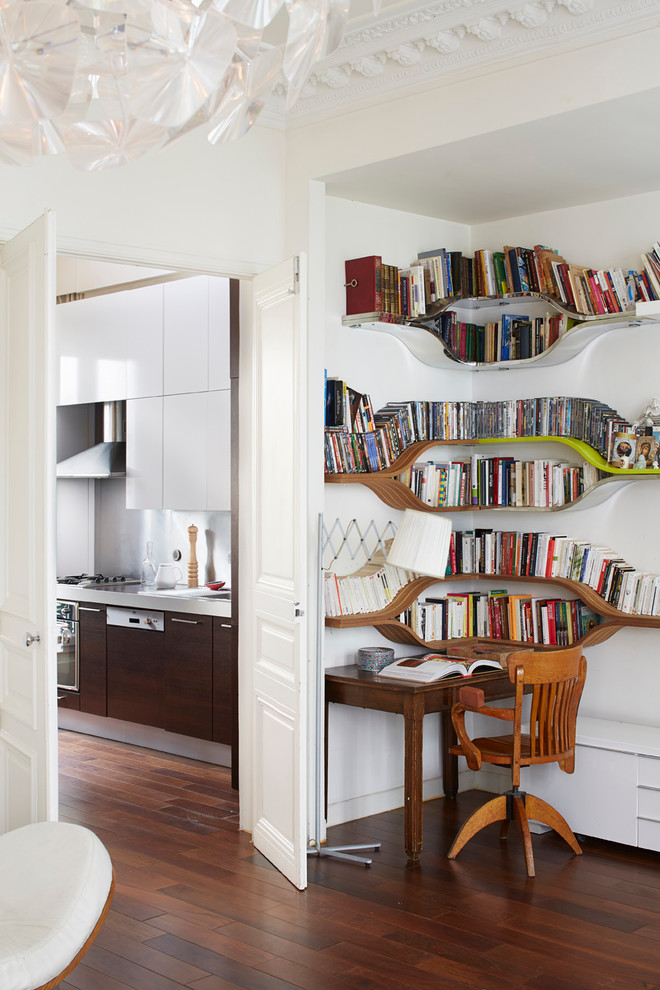 Inspiration för ett funkis hemmabibliotek, med vita väggar, mörkt trägolv och ett fristående skrivbord