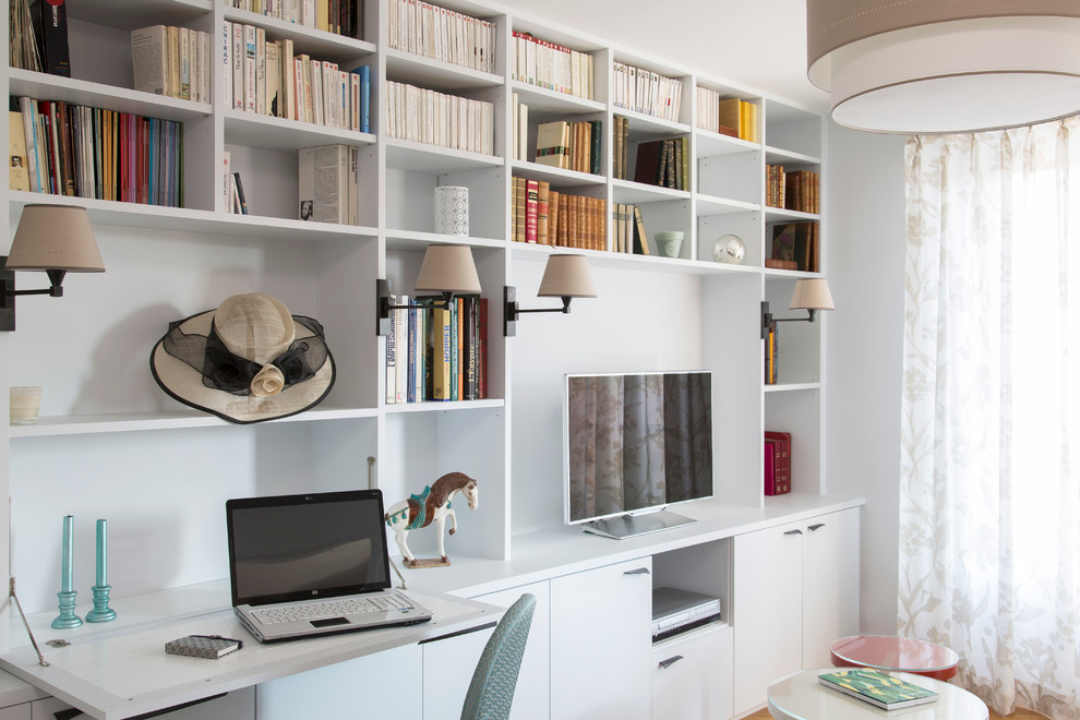 Exemple d'un bureau tendance de taille moyenne avec un bureau intégré, un mur blanc et un sol en bois brun.