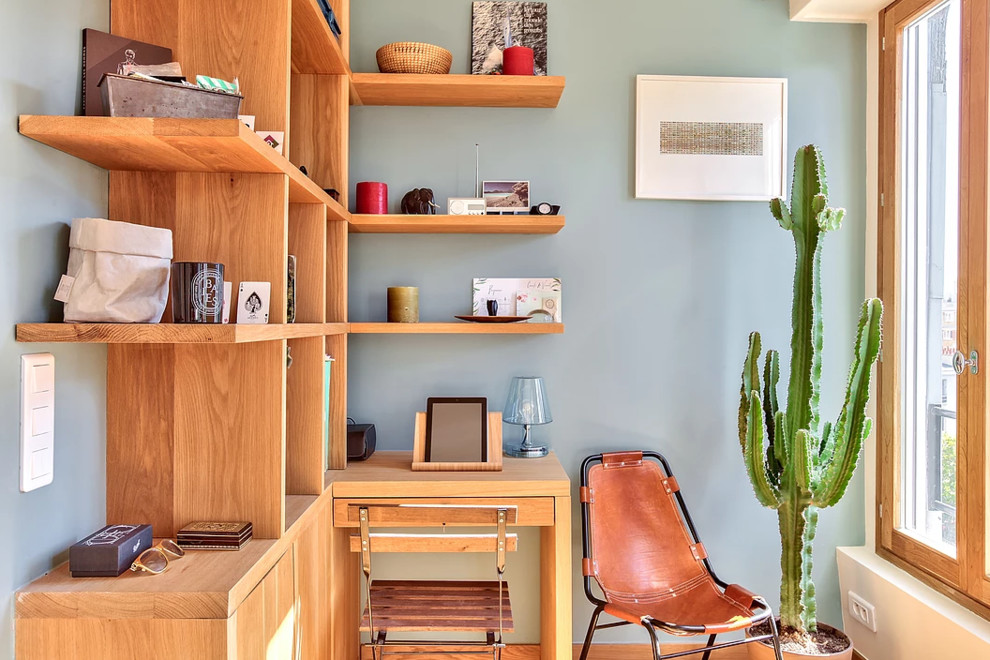 Idée de décoration pour un bureau design de taille moyenne avec un mur bleu, un sol en bois brun, aucune cheminée, un bureau intégré et un sol marron.