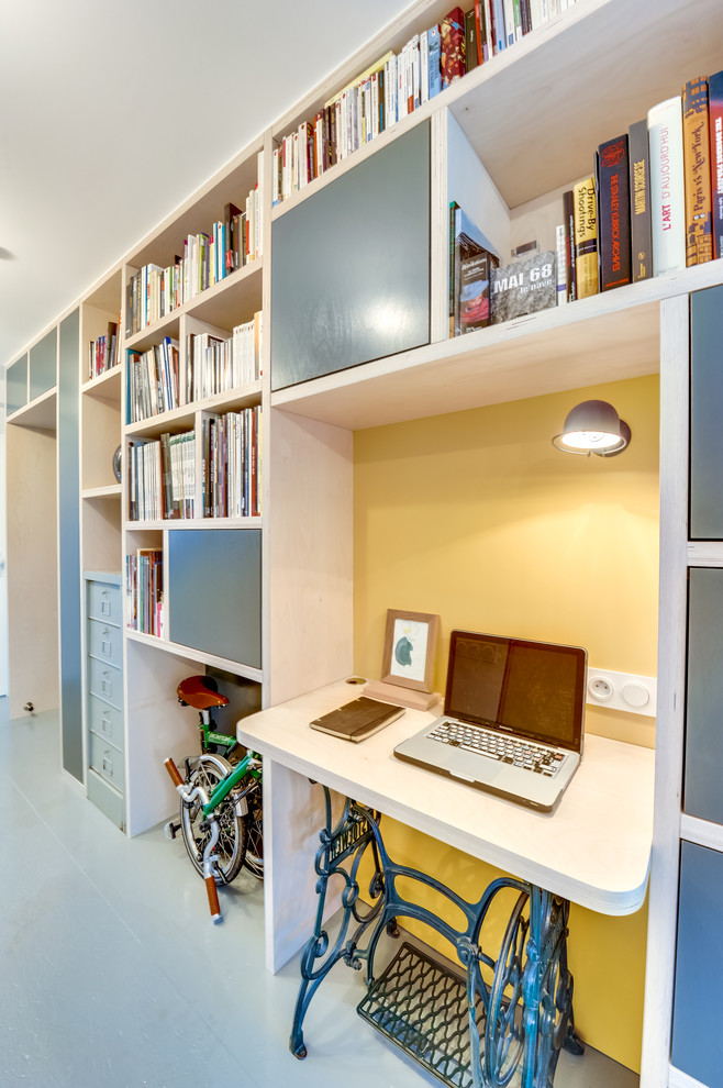 Immagine di un piccolo ufficio moderno con pareti gialle, pavimento in legno verniciato, nessun camino e scrivania incassata