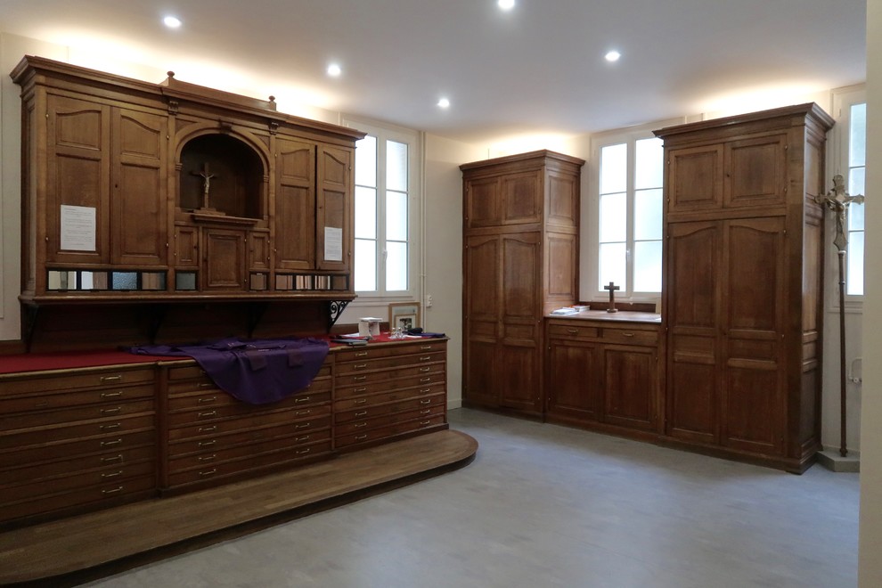 Modelo de despacho clásico renovado grande sin chimenea con paredes beige, suelo vinílico y suelo beige