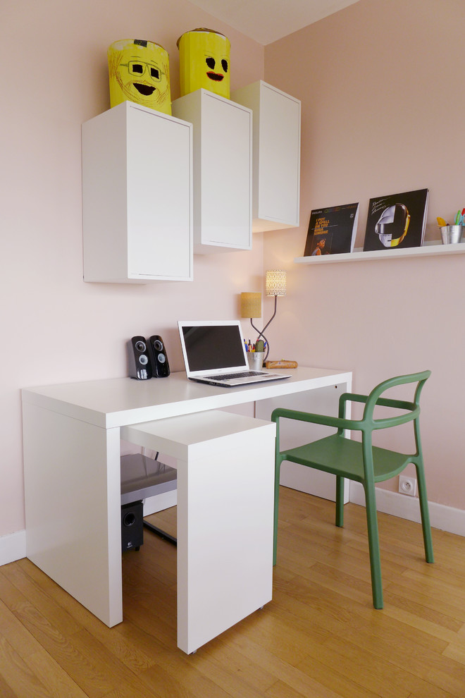Idéer för ett modernt hemmabibliotek, med rosa väggar, ljust trägolv, ett fristående skrivbord och brunt golv