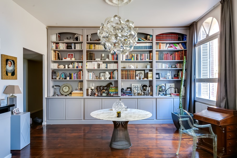 This is an example of a large contemporary study in Paris with medium hardwood flooring, a freestanding desk and white walls.