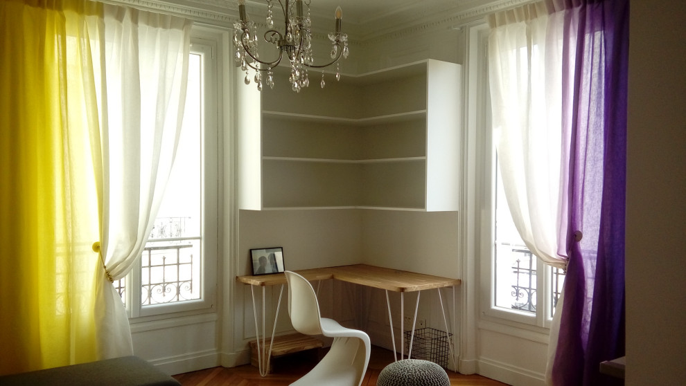 Ejemplo de despacho minimalista de tamaño medio con paredes blancas, suelo de madera clara, chimenea de esquina, marco de chimenea de piedra, escritorio empotrado y suelo beige