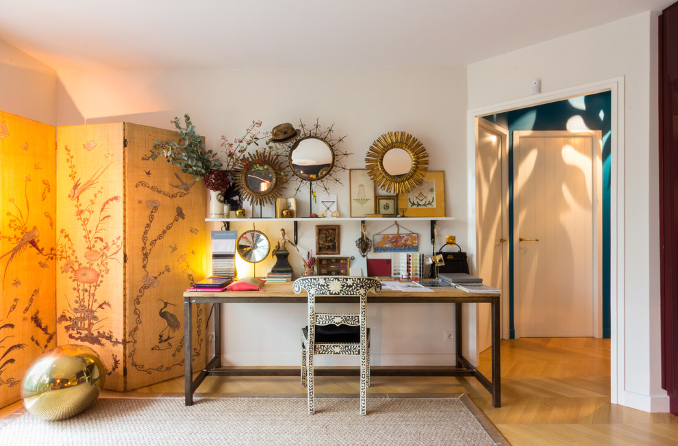 Mittelgroßes Eklektisches Arbeitszimmer ohne Kamin mit Arbeitsplatz, weißer Wandfarbe, braunem Holzboden und freistehendem Schreibtisch in Paris