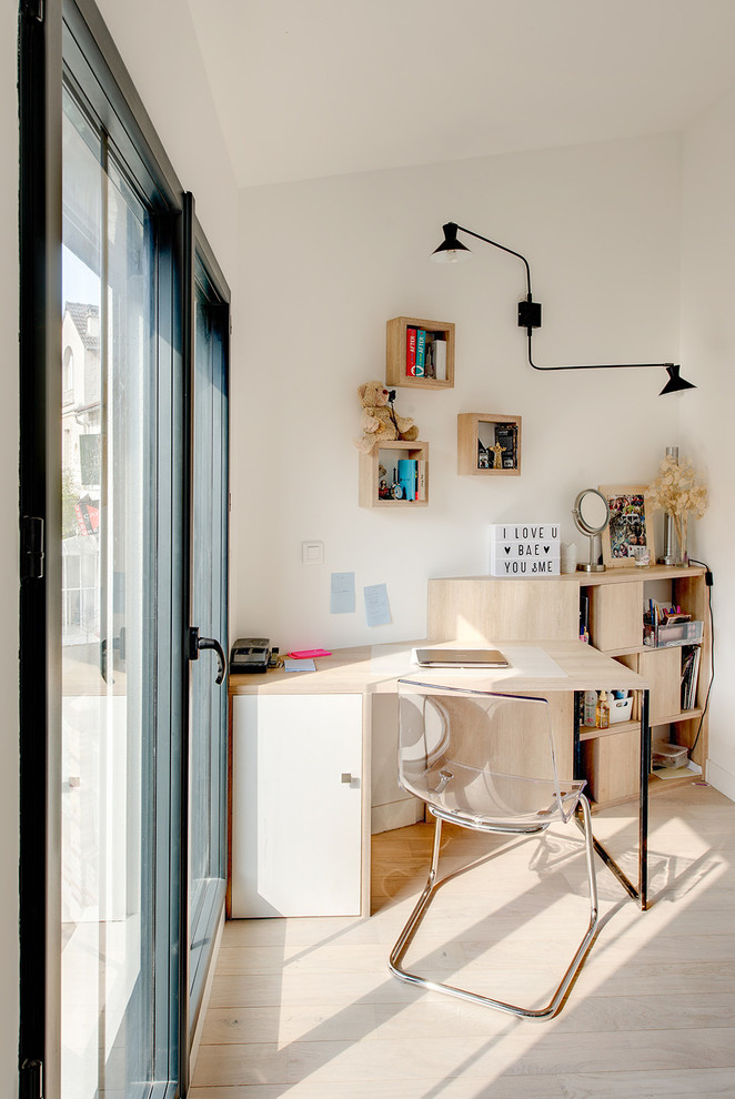 На фото: рабочее место в современном стиле с белыми стенами, светлым паркетным полом, отдельно стоящим рабочим столом и бежевым полом с