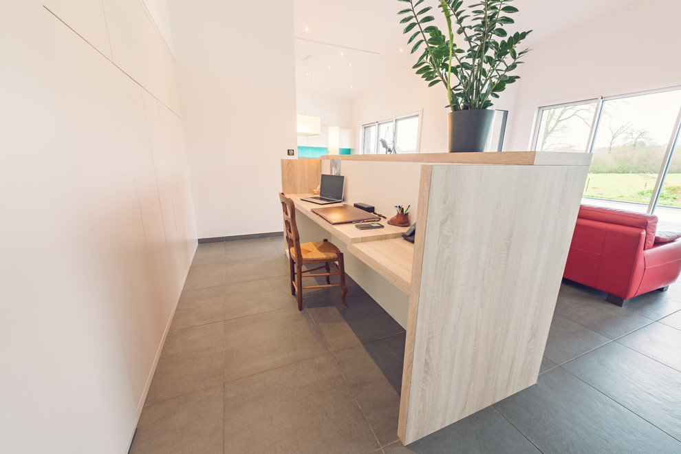 Modelo de despacho nórdico pequeño con paredes blancas, suelo de pizarra, escritorio empotrado y suelo gris